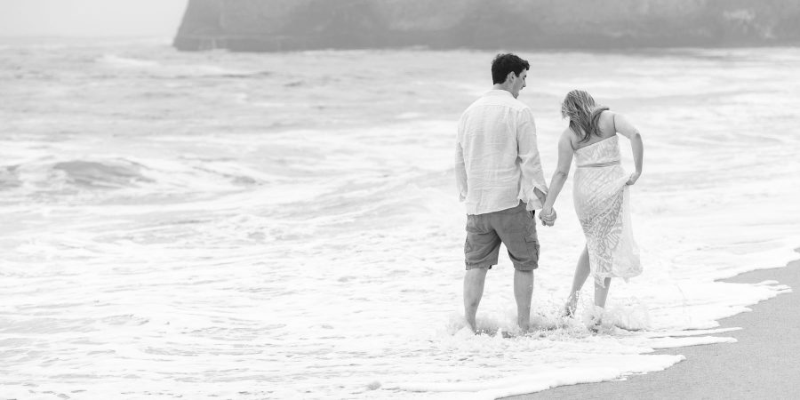 B&W walking on the beach, water splashing over feet - Davenport Beach Wedding / Engagement Proposal Photography - Julianna and Brian - photos by Bay Area wedding photographer Chris Schmauch www.GoodEyePhotography.com