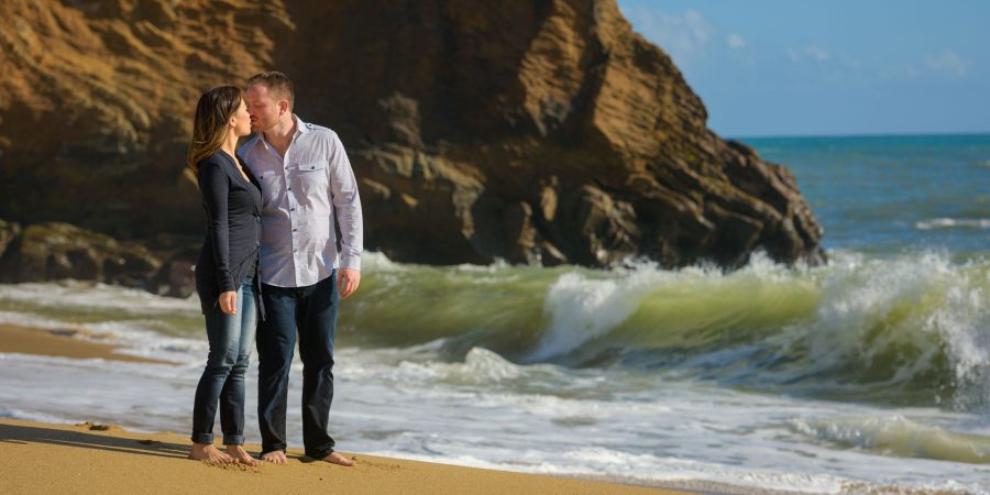 Kissing while a green wave crashes in the background - Panther Beach Santa Cruz and Quail Hollow Felton engagement photography - Sara and Scott - photos by Bay Area wedding photographer Chris Schmauch