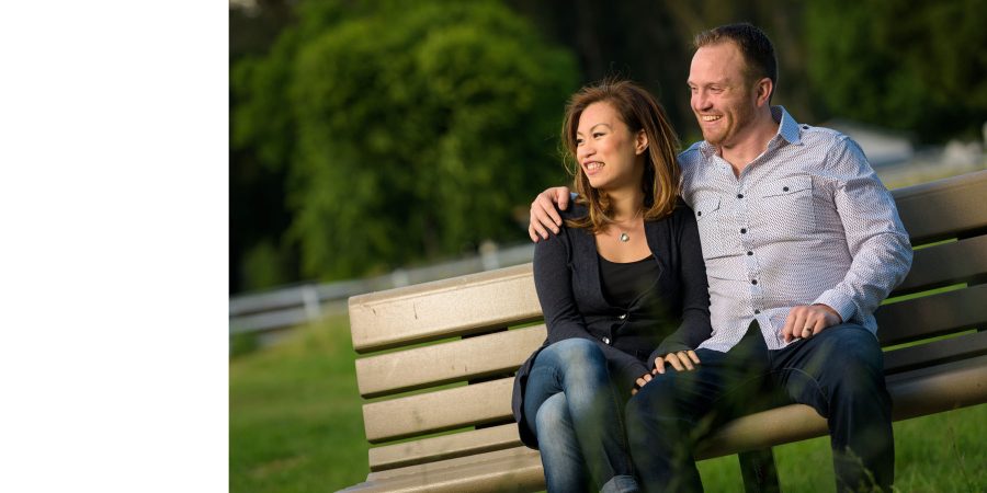 Couple sitting on the bench and smiling off-camera - Panther Beach Santa Cruz and Quail Hollow Felton engagement photography - Sara and Scott - photos by Bay Area wedding photographer Chris Schmauch